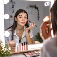 Chica muy guapa maquillándose con un kit de cosmética vegano