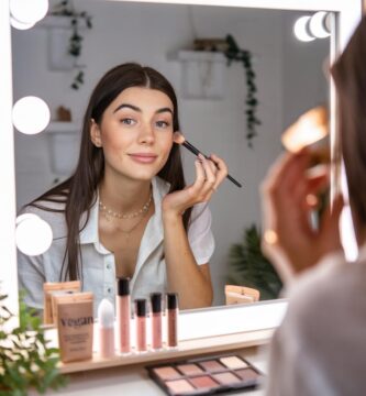 Chica muy guapa maquillándose con un kit de cosmética vegano